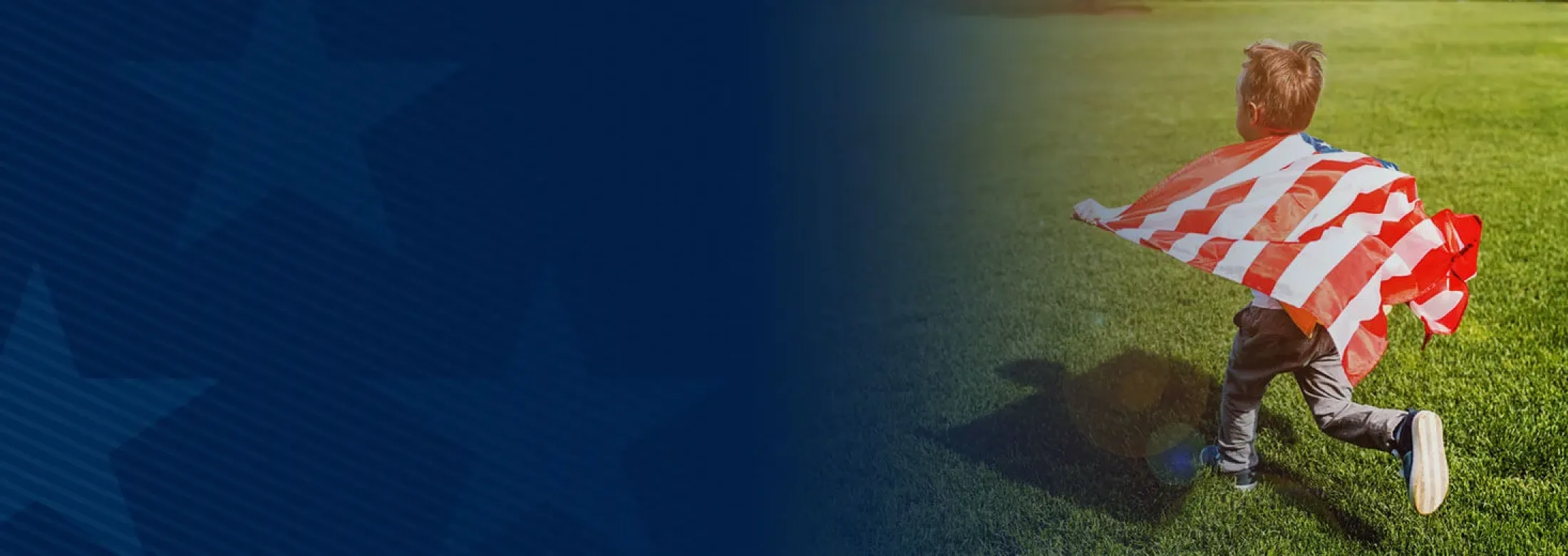 boy running with an american flag across green grass